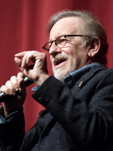 Steven Spielberg speaking into microphone and gesturing with hands, at Jacob Burns Film Center