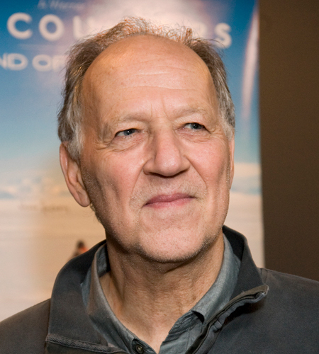 Werner Herzog headshot in front of film poster