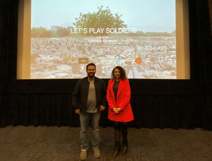 artists in residence mariam al dhubhani and mohammed al jaberi standing in front of film still projection