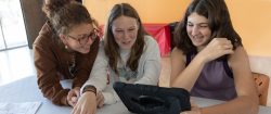 Three teenage girls view a laptop screen