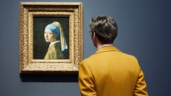Still of a person looking at the painting The Girl With a Pearl Earring